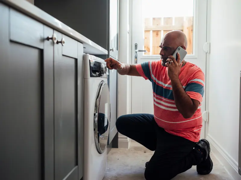 A man determining whether to repair or replace his washer.