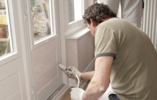 Home repair showing worker painting an interior door.